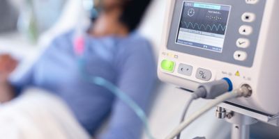 Woman in hospital bed with oxgen machine in the fore ground