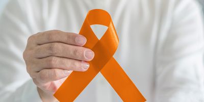 Person holding an orange ribbon