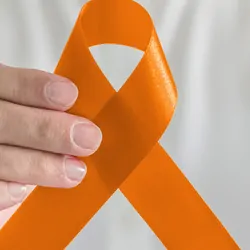 Person holding an orange ribbon