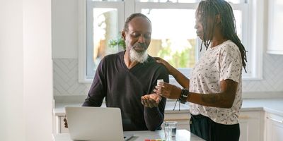 Photograph of a person completing his cognitive assessment and taking medications given by his caregiver as he recovers from COVID-19 months after infection. 