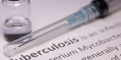 A needle and medication on a piece of paper that says Tuberculosis