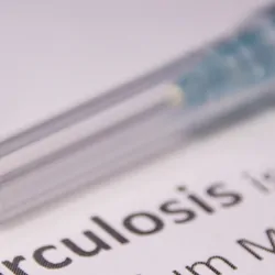 A needle and medication on a piece of paper that says Tuberculosis