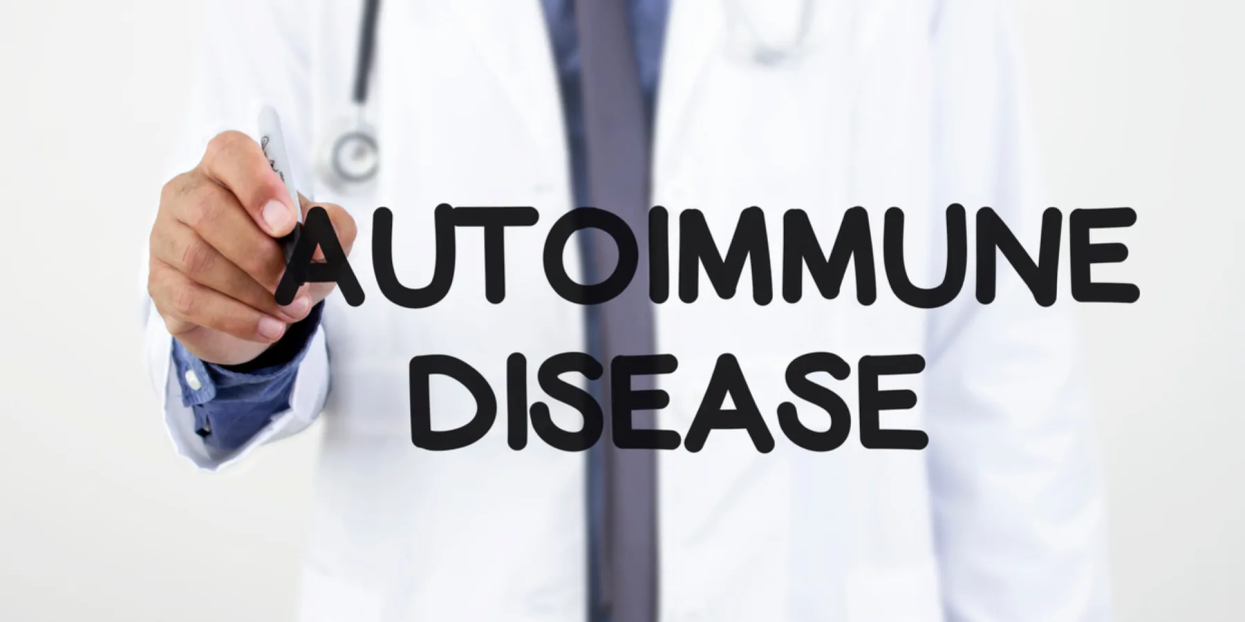 Doctor writing "Autoimmune Disease" in black marker on a window
