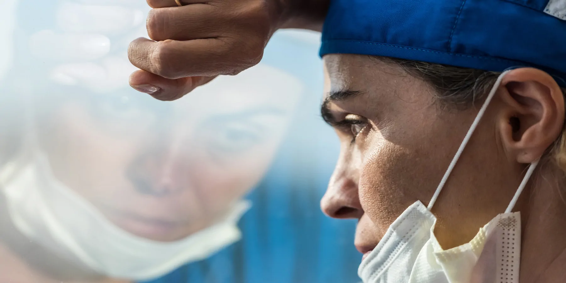 Medical professional stressed and sad looking out a window