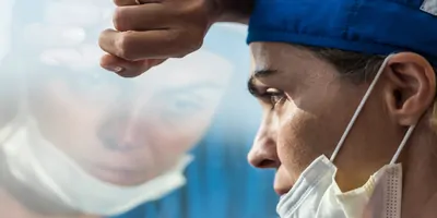 Medical professional stressed and sad looking out a window