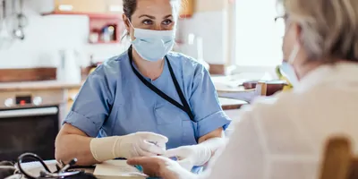 Elderly person having their blood drawn at home by a health care professional