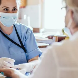 Elderly person having their blood drawn at home by a health care professional