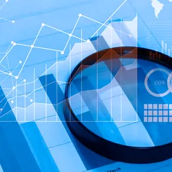Magnifying lense on a paper with charts