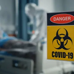 Health care professionals in full PPE working in a COVID-19 ward