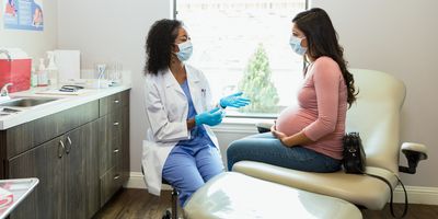 A doctor talks to a pregnant patient about non-invasive pregnancy screening tests.