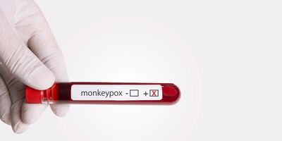 Gloved hand holding a blood vial