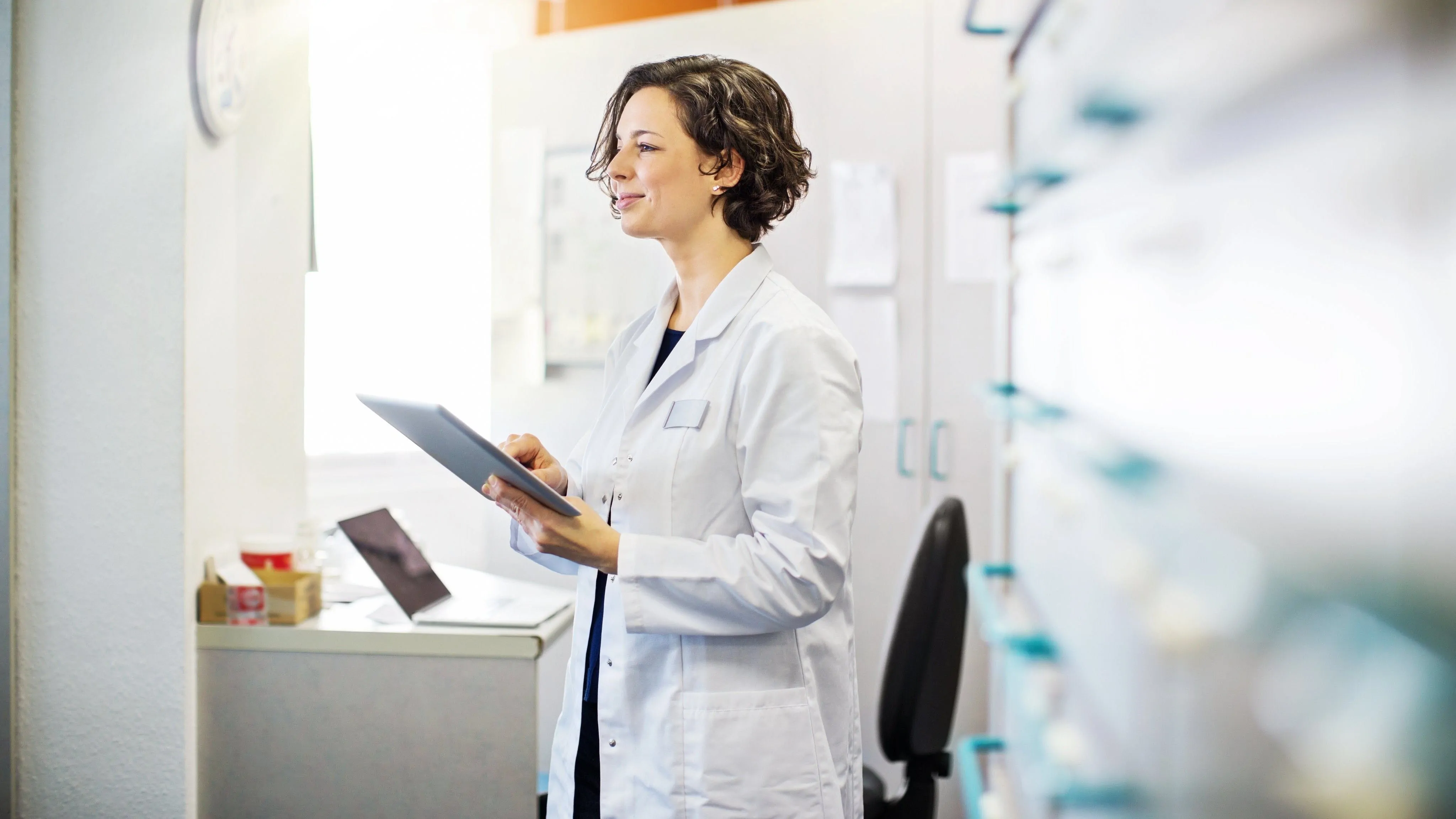 qiagen-clinical-insights-interpret-one-ebook A clinical lab professional holding a tablet with an easily-generated, comprehensive, and clinically interpretable report of NGS data for a patient with rare cancer.