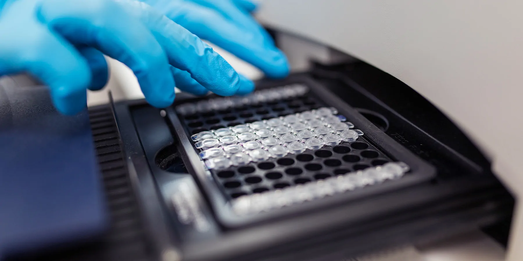 Automating Synthetic Biology’s Future Photo of a clinical lab professional loading an mRNA plate into automation platform.