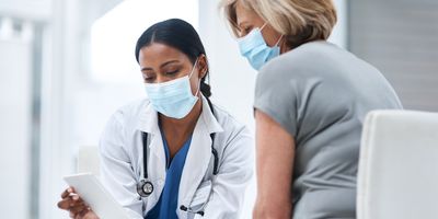 Shot of a young doctor using a digital tablet during a consultation with a senior woman