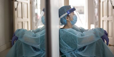 Health care worker sitting exhausted on the floor