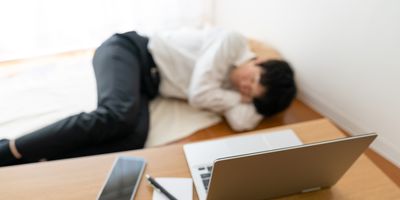 Photo of a clinical professional lying on the ground after a virtual meeting.