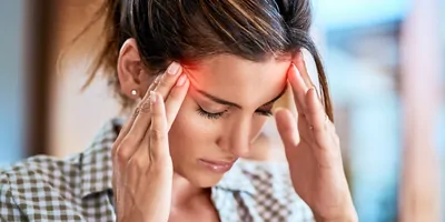 Shot of a uncomfortable looking woman holding her head in discomfort