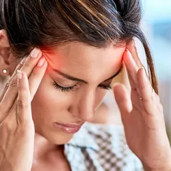 Shot of a uncomfortable looking woman holding her head in discomfort