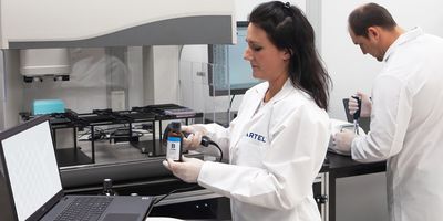 Photograph of lab personnel using automated liquid handlers for increased productivity.