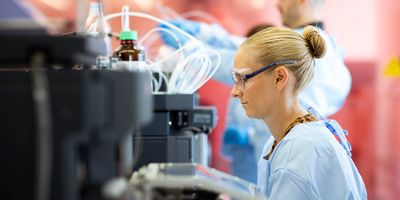 Photo of a clinical professional at a MALDI-TOF MS instrument in a clinical lab.