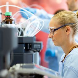 Photo of a clinical professional at a MALDI-TOF MS instrument in a clinical lab.