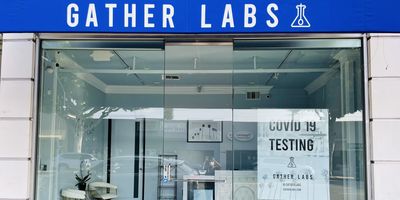 Photo of the Gather Labs storefront with a sign in the window advertising COVID-19 diagnostic testing.