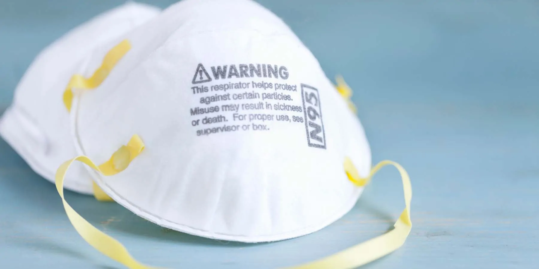 Photo of a white N95 mask with the word "warning" written on it.
