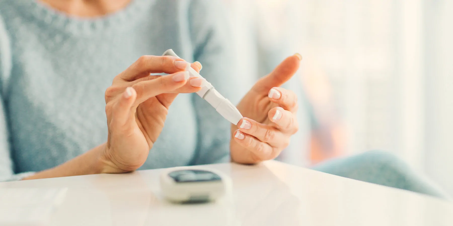 Mature woman doing blood sugar test at home in a living room