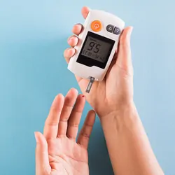 Diabetic measuring the level of glucose in their blood on a ble background