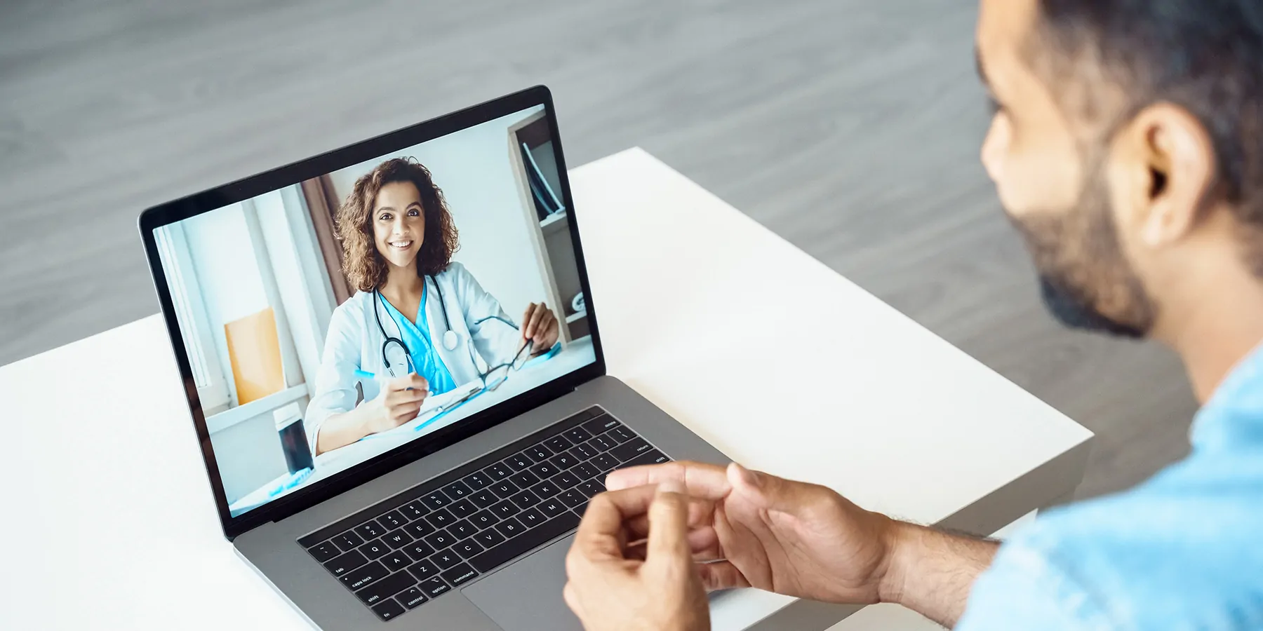 View over male client shoulder sit at desk receive medical consultation online from female doctor