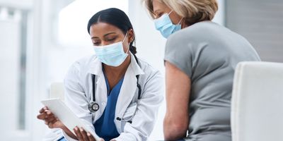 Shot of a young doctor using a digital tablet during a consultation with a senior woman