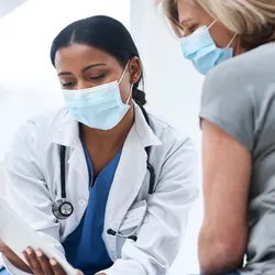Shot of a young doctor using a digital tablet during a consultation with a senior woman