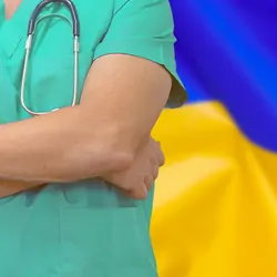 Male surgeon or doctor with stethoscope on the background of the Ukraine flag