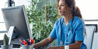 Shot of female doctor talking with earphone while explaining medical treatment to patient through a video call 