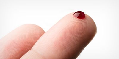 Photograph of a drop of blood on a finger, depicting blood-testing whether in the clinic or at home.