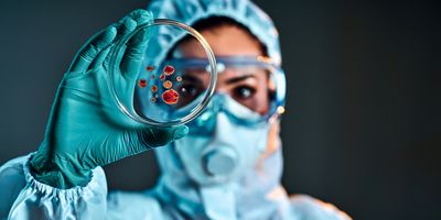 Selective focus of biochemist taking biomaterial from petri dish