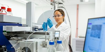 Laboratory technician inspecting sample from mass spectrometry device to discover biomarkers