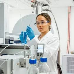 Laboratory technician inspecting sample from mass spectrometry device to discover biomarkers