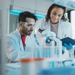 Researchers using a microscope in lab