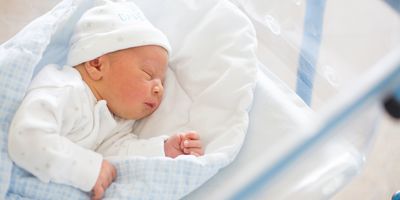 Photograph of a newborn baby in a prenatal ward to represent the importance of newborn screening for timely intervention in infants with genetic disorders.