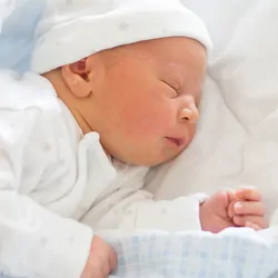 Photograph of a newborn baby in a prenatal ward to represent the importance of newborn screening for timely intervention in infants with genetic disorders.