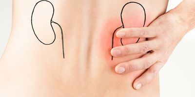 Young male adult holding his back because of pain