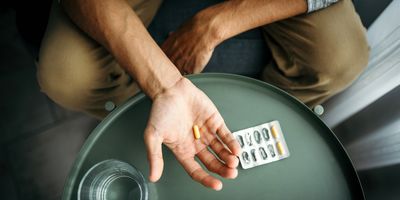 Man holding pill in his hand