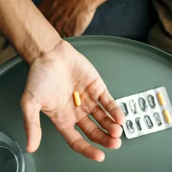 Man holding pill in his hand