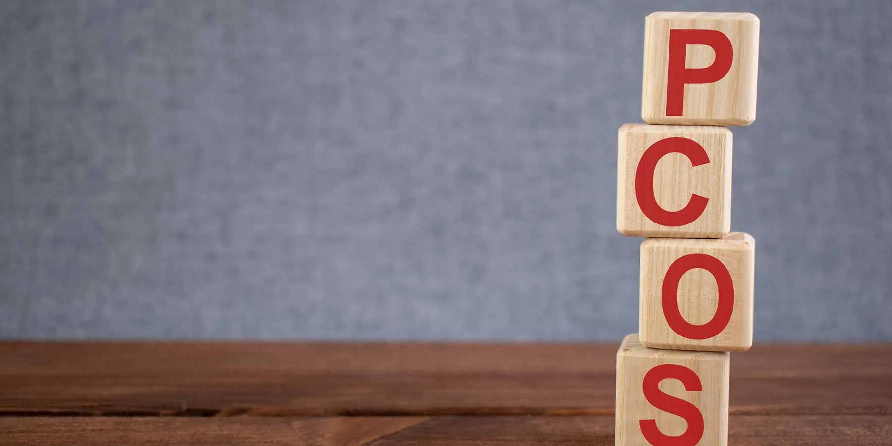 Abbreviation PCOS (polycystic ovarian syndrome) text acronym on wooden cubes