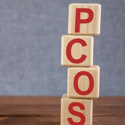 Abbreviation PCOS (polycystic ovarian syndrome) text acronym on wooden cubes