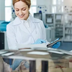 Photograph of two clinical lab personnel discussing and monitoring the flow cytometry workflow on their handheld tablet device.
