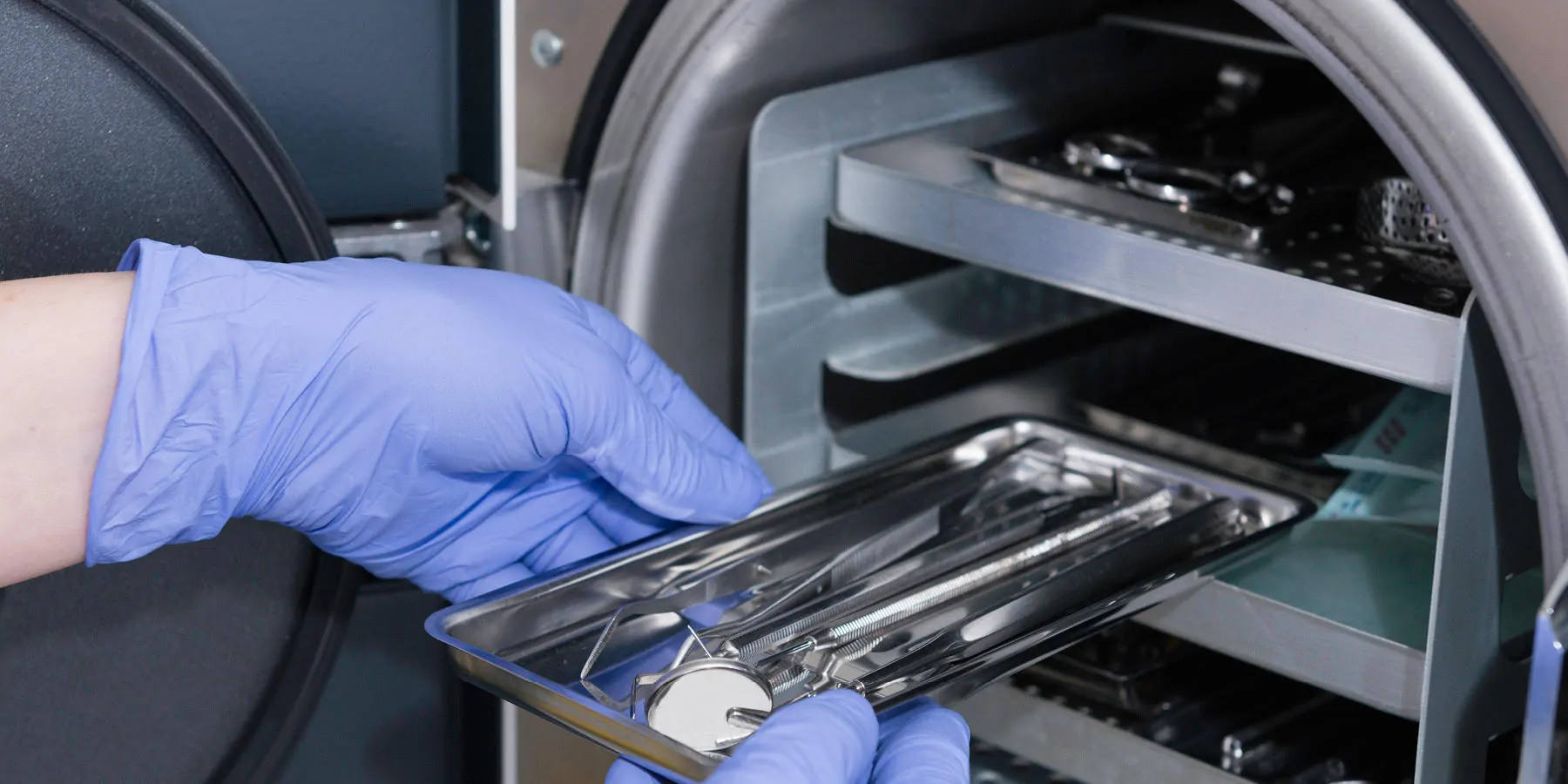 Health care provider putting medical instruments in an autoclave
