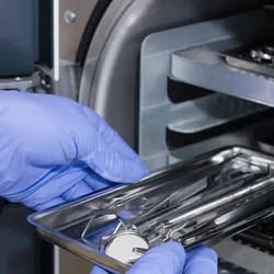 Health care provider putting medical instruments in an autoclave