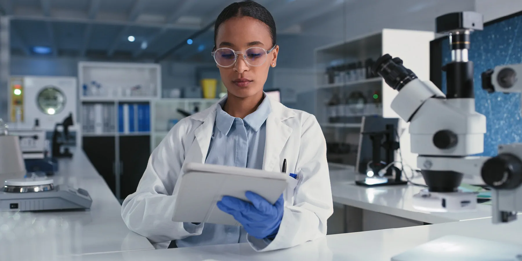 Photo of a Black clinical laboratory professional holding a clinical trial lab manual in a laboratory.